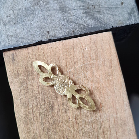 Back view of the brass leaf setting with visible heat damage from an overheated soldering attempt.