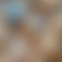 Close‑up of polished blue jasper beads showing soft marbled patterns in muted blue and earthy tones.