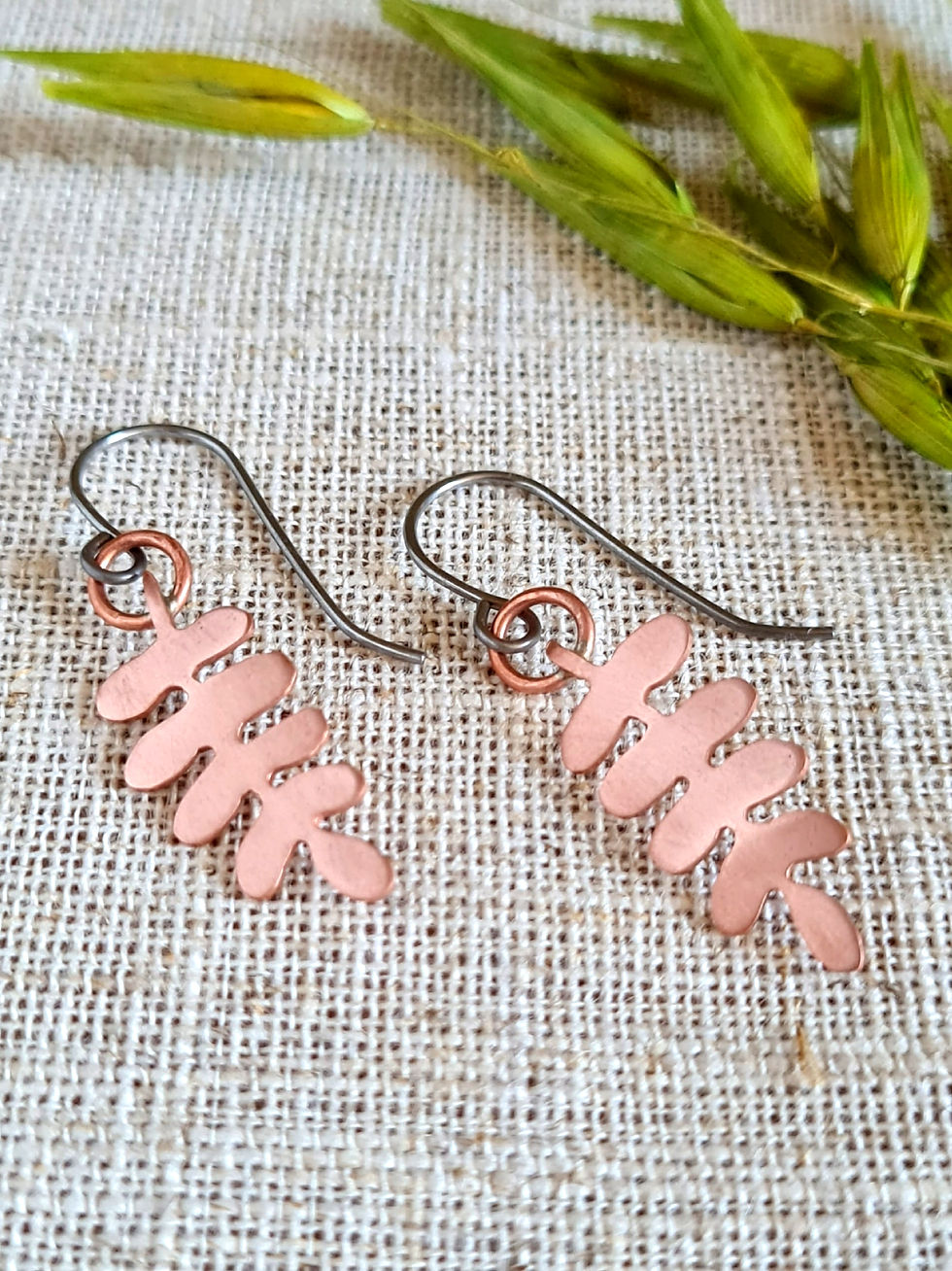 Thumbnail: Handcrafted earrings featuring a copper fern leaf silhouette and niobium ear wires.