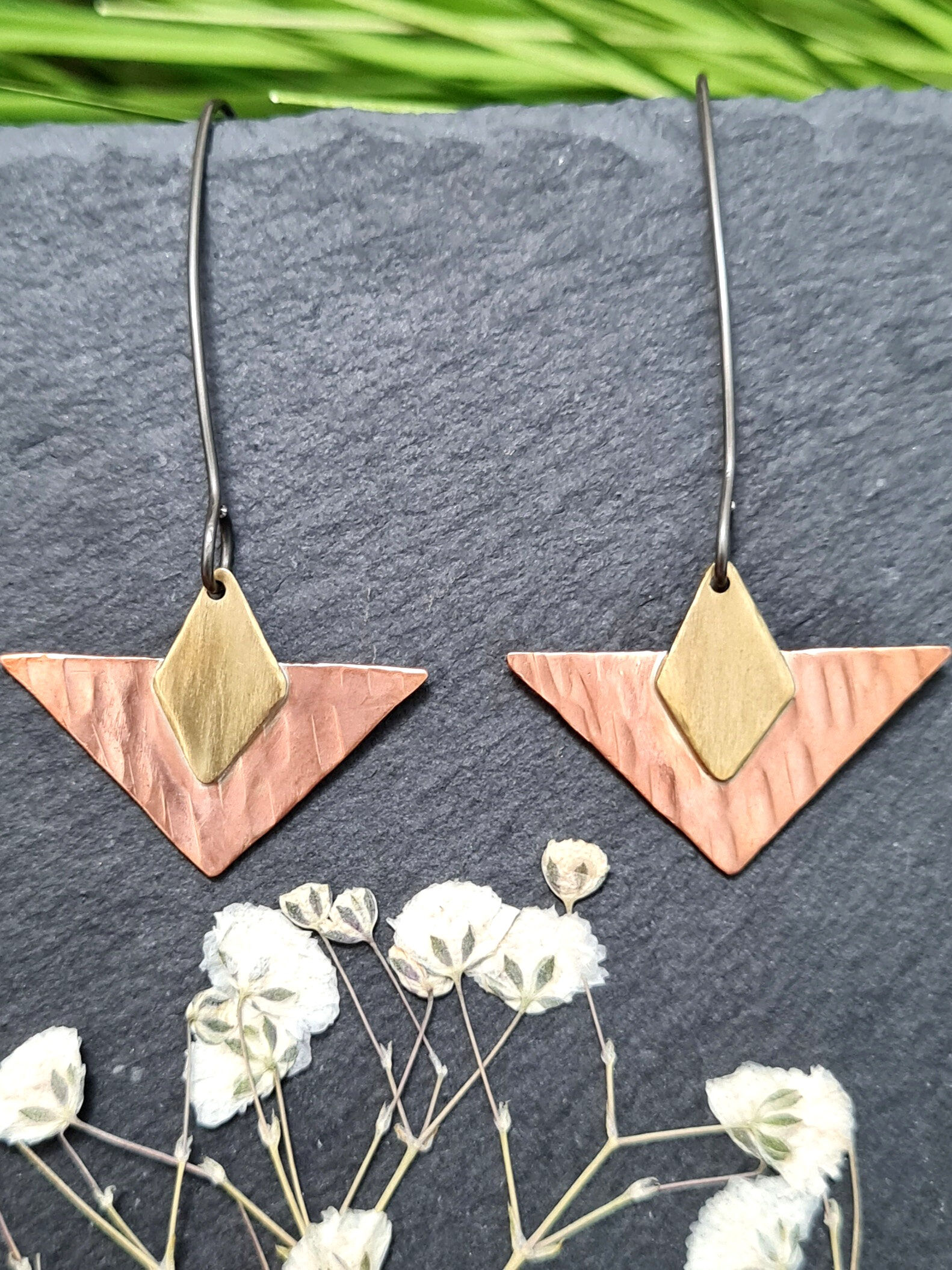Triangle Drop Earrings hand made from copper and brass shown against slate background.