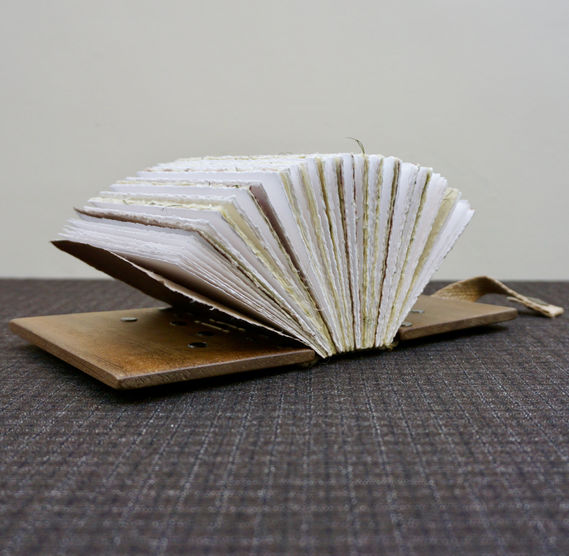 A handmade Iroko wood open notebook with beautiful deckled pages.