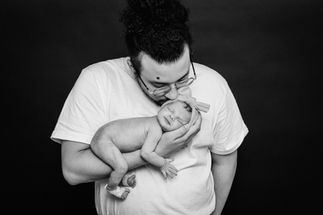 Father bonding with newborn in black-and-white portrait