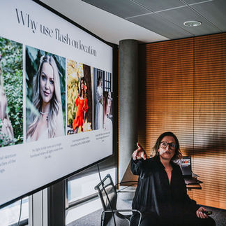 sitzt vor einem Fernseher mit ihrem Fashion-Portfolio und erläutert ihre Arbeitsweise