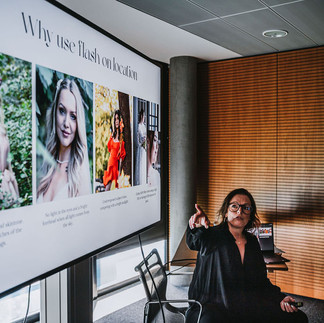 sitzt vor einem Fernseher mit ihrem Fashion-Portfolio und erläutert ihre Arbeitsweise