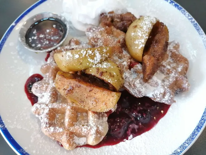 vegan waffles with fruit and sauce and icing sugar