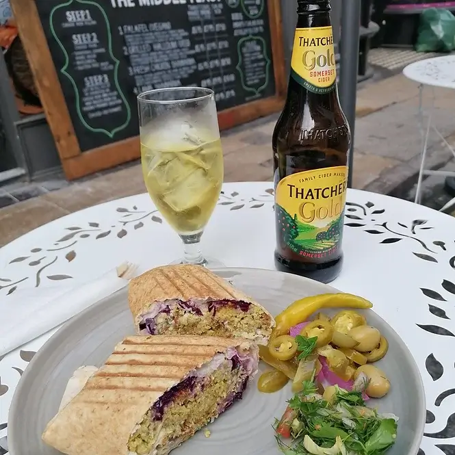 falafel sandwich with salad and cider bottle/glass