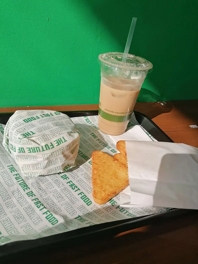 breakfast muffin wrapped in fast food paper with hashbrowns and milkshake