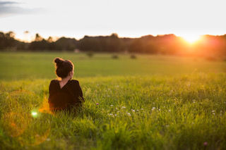 A woman sitting in a field