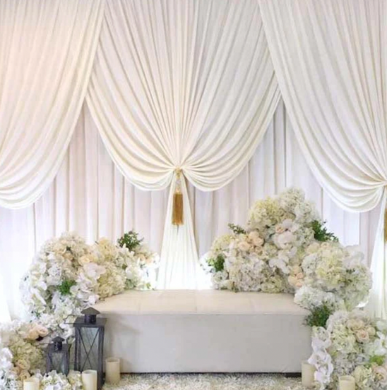 Luxury white sweetheart table backdrop with elegant draping and flowers