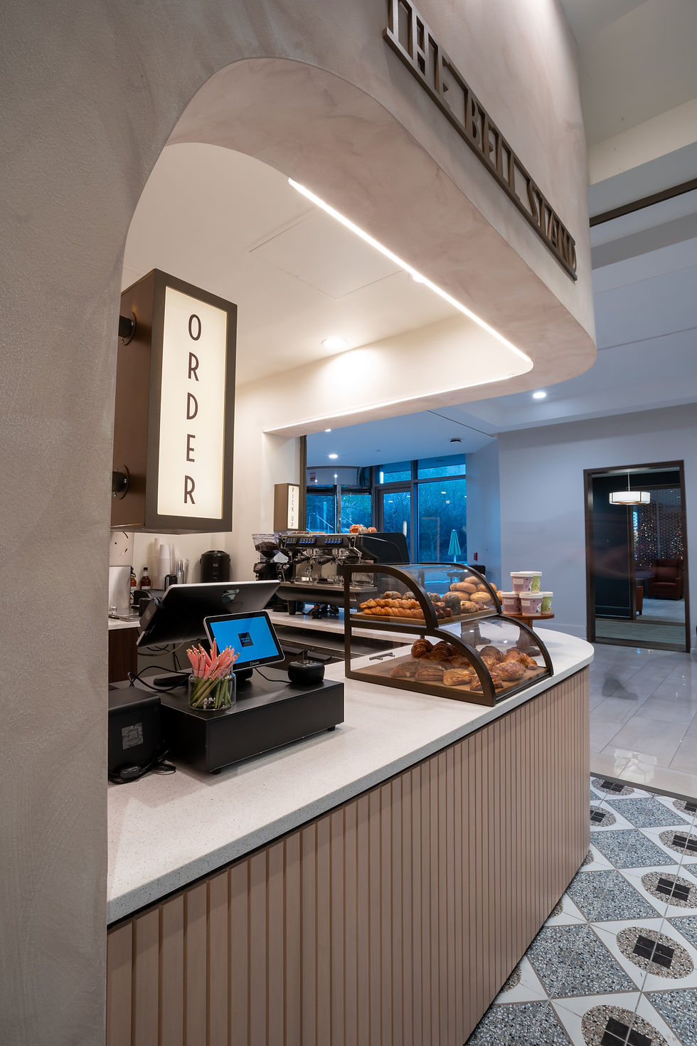The Bell Stand cafe ordering counter with signature pastry display and an illuminated 'ORDER' sign.