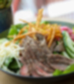 Grilled steak salad with cheese, cucumbers, pickled onions, tortilla strips, and greens at Uno Más Taqueria in Buckhead
