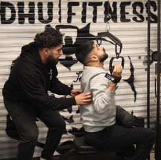 Personal training class with a personal trainer helping his client 