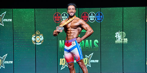 personal trainer in houslow who has won a bodybuilding event and is showing his medals