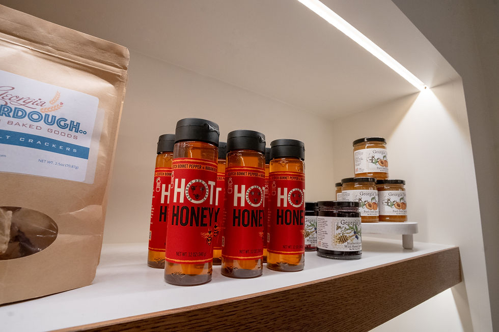 Retail shelf displaying Hot Honey bottles from Red Clay and Georgia honey products, with Sourdough crackers visible in the foreground.