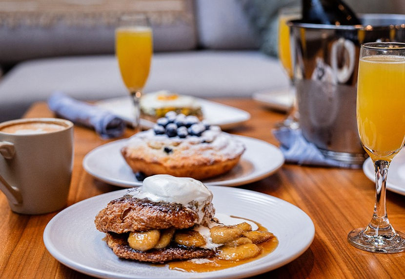 Breakfast, including coffee, orange juice, and blueberries, set out on a wooden table