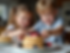 happy children decorating fluffy pancakes with berries and cream.png
