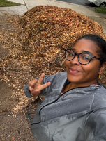 Farmer Mel in front of a pile of mulch.