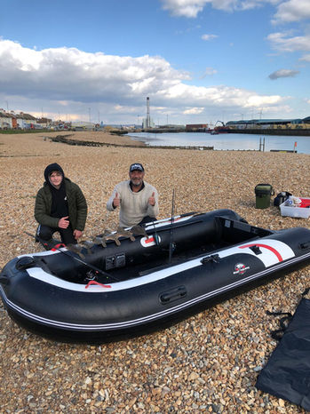 Inflatable boat anglers with their catch of Plaice fish