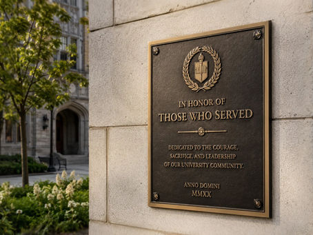 Custom embossed memorial metal plaque with raised lettering on a university building wall