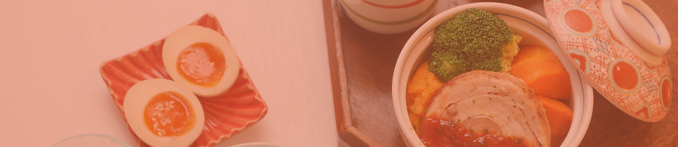 Close-up banner view of soft-boiled eggs and a chashu pork dish served in traditional ceramic tableware at Grandmama Cafe in Hong Kong.