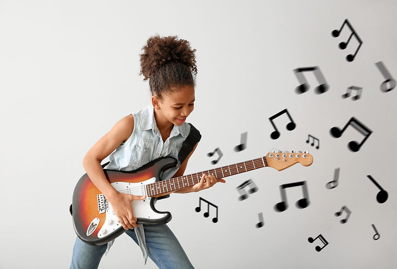 Girl smiling while playing music on a guitar