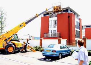 Photo of a crane moving a house