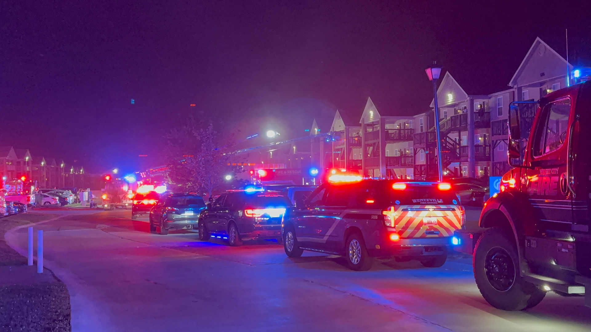 Emergency vehicles from multiple departments line the roadway during a second-alarm apartment fire near Killdeer Circle and Mette Road in Moscow Mills.