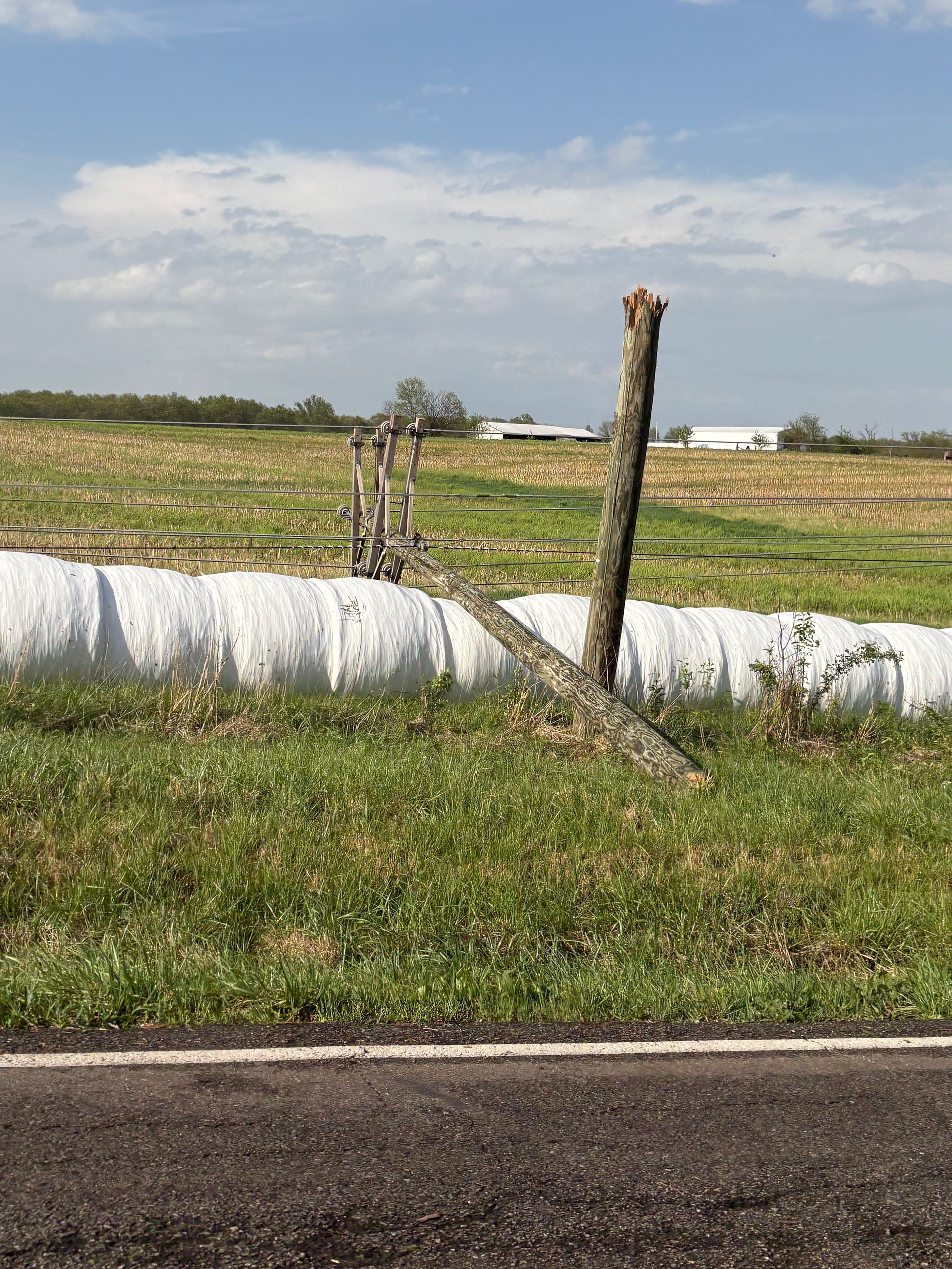 Damaged fencing and debris scattered across a rural field after severe storms in Lincoln County.