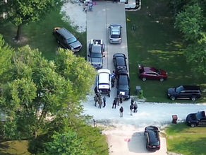 Aerial view of law enforcement vehicles staged near Pinewood Drive during an active barricaded subject incident in Winfield, Missouri.