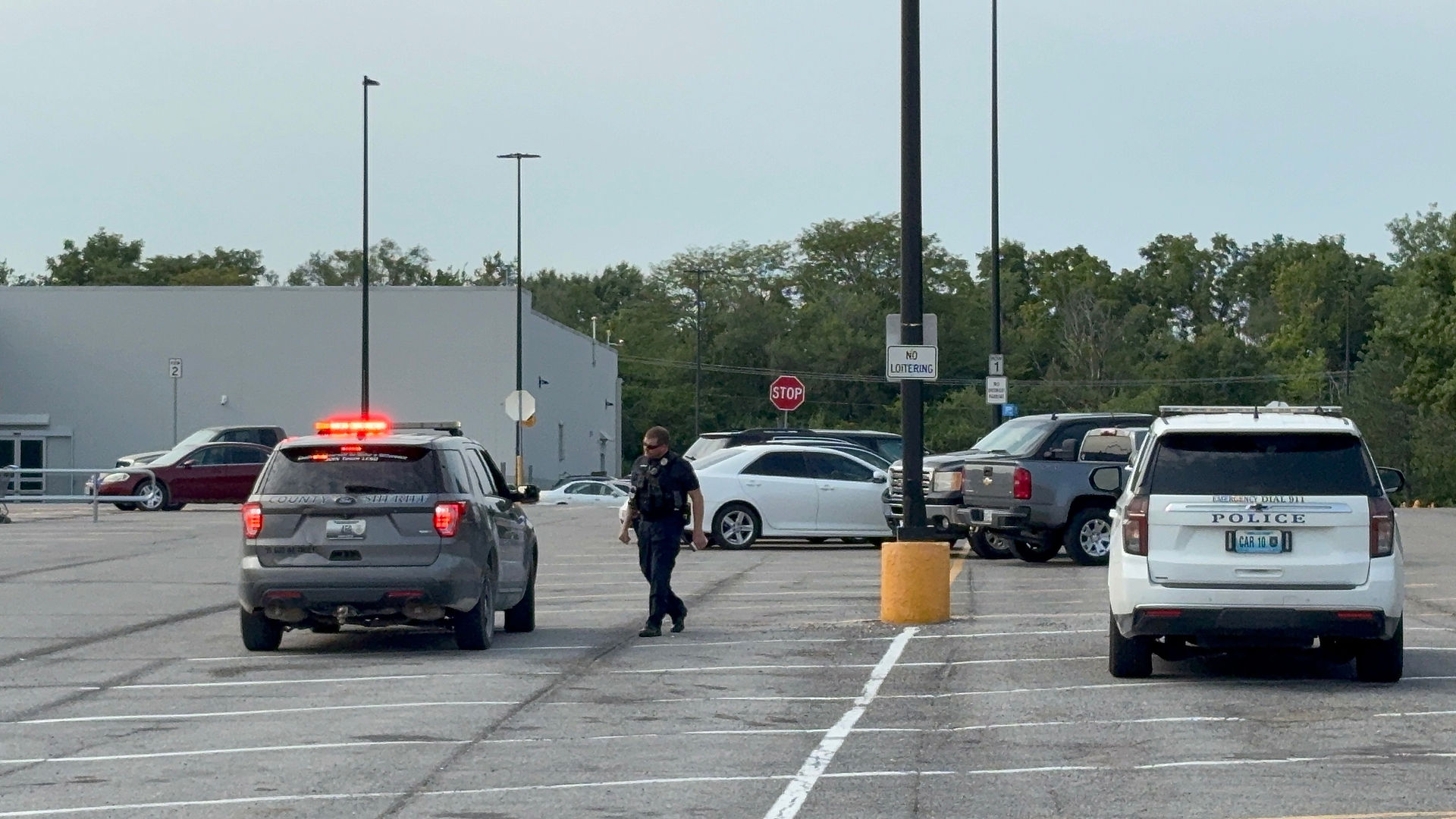 Law enforcement officers and police vehicles in the Troy Walmart parking lot during the Aug. 10, 2026, evacuation and search.