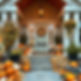 Porch on expensive modern home decorated with hundreds of orange and white pumpkins, green