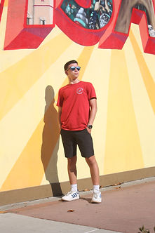 Man standing in front of mural with red t-shirt