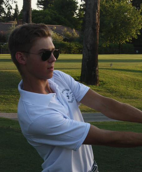 Man swinging golf club with white polo