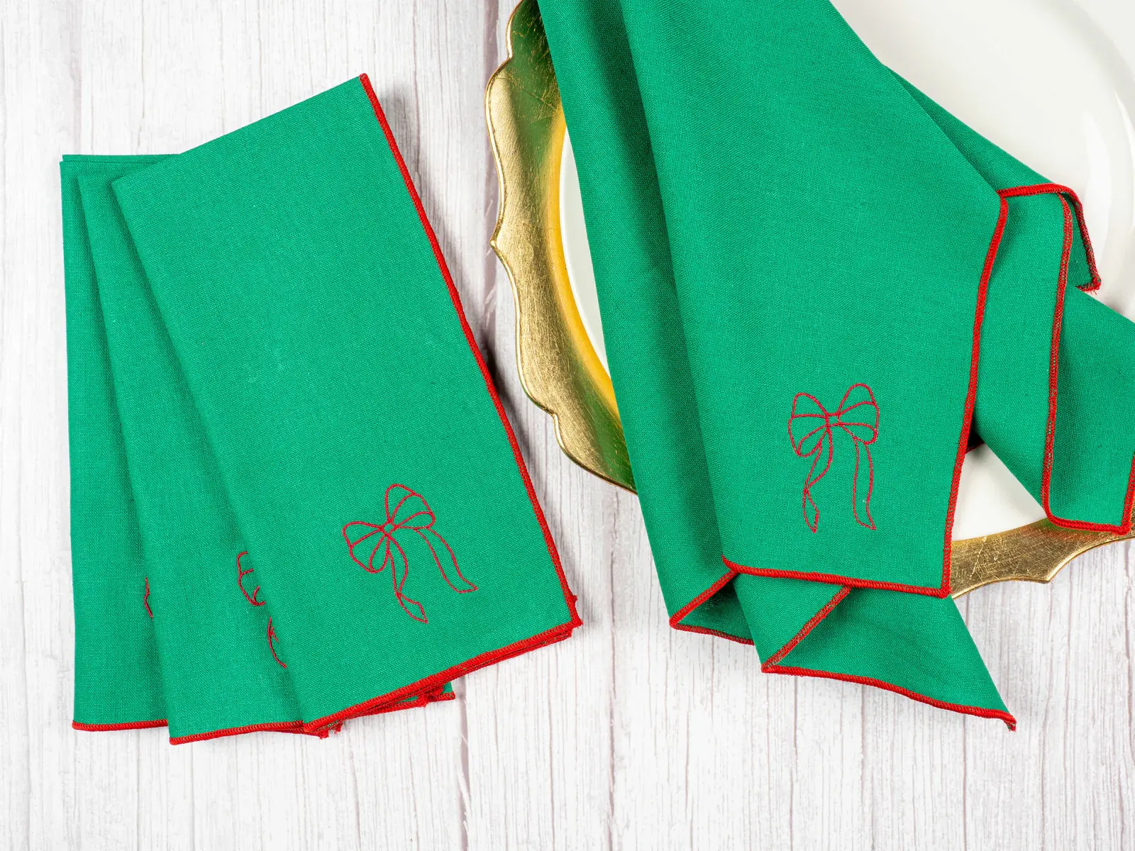Festive holiday table featuring green linen napkins with red bows