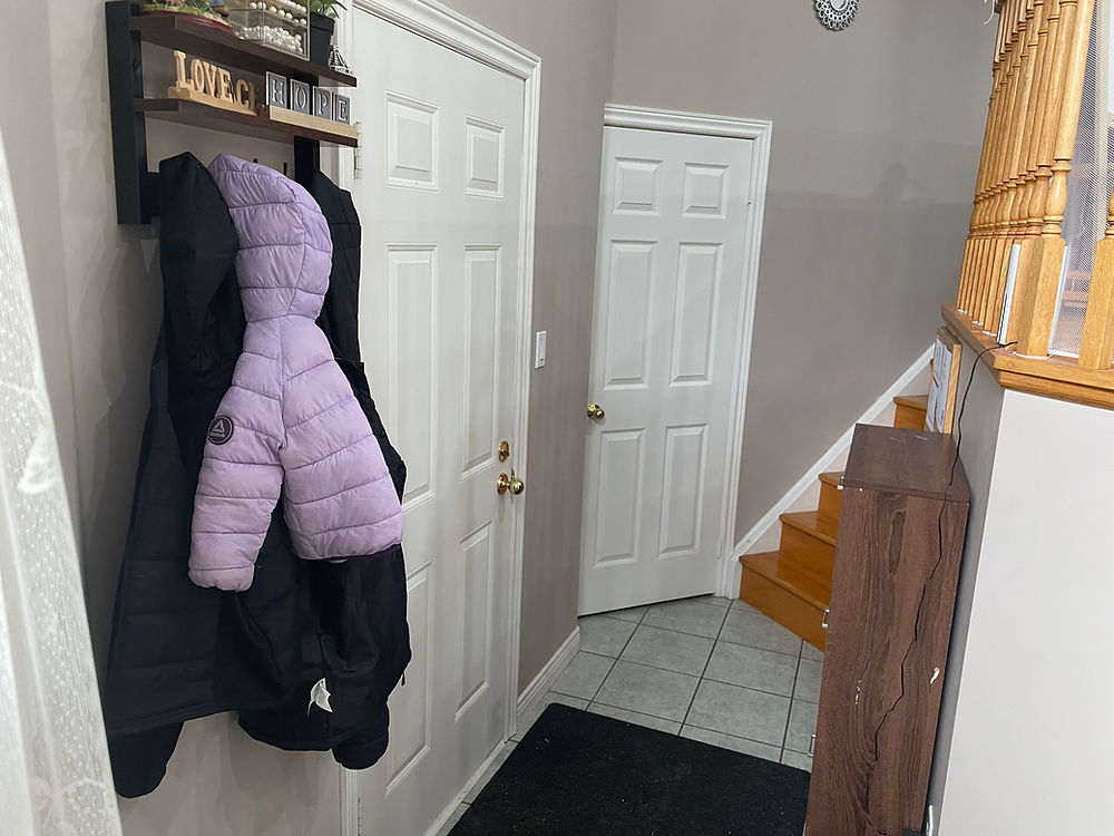 Hallway with coat rack, purple jacket, and stairs
