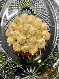 Closeup of frosting on a cupcake on a pressed glass dish