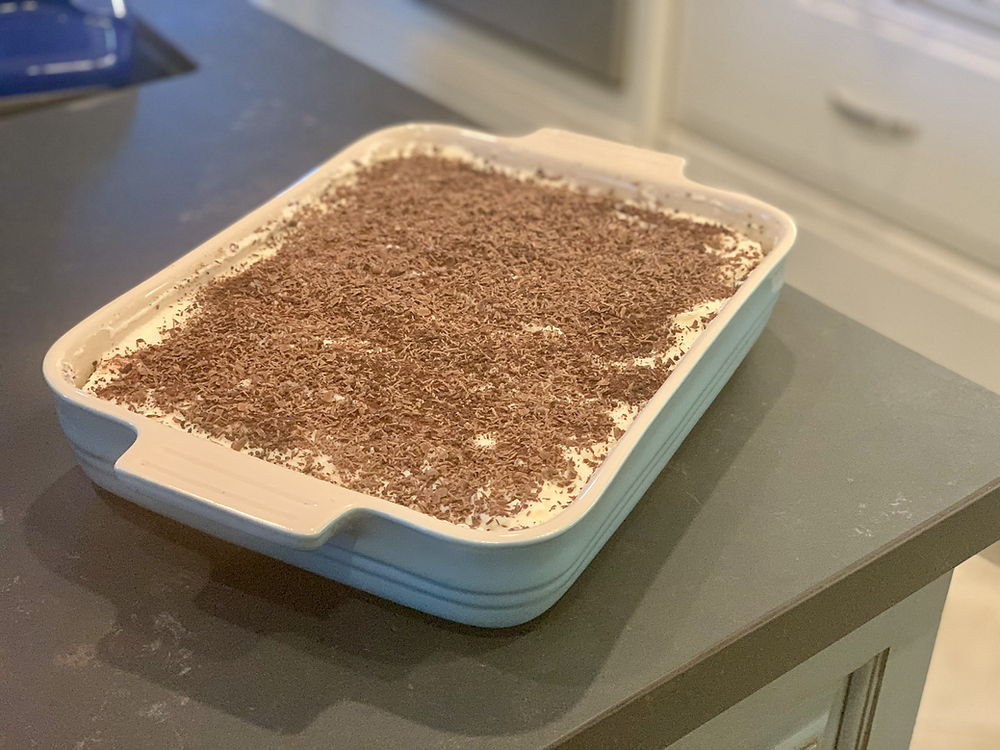 a completed platter of tiramisu on a black counter