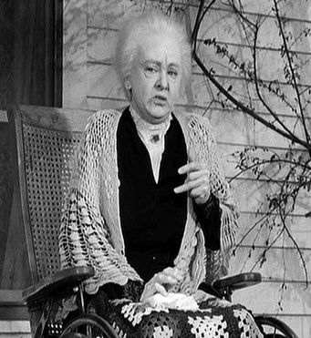A photo from a cinematic adaptation of Harper Lee's novel To Kill a Mockingbird, which shows Mrs. Dubose, a judgmental, elderly neighbor who is determined to break her morphine dependency before she dies so that she is "beholden to nothing and nobody" when she leaves this Earth.