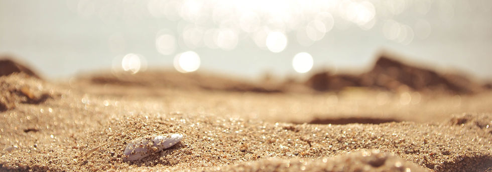 Close up of sand on a beach, with out of focus sea in the background