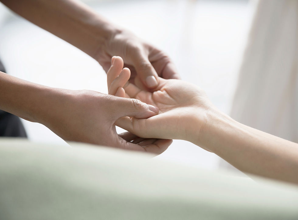 Using both hands a therapist is gently supporting a client's upturned hand
