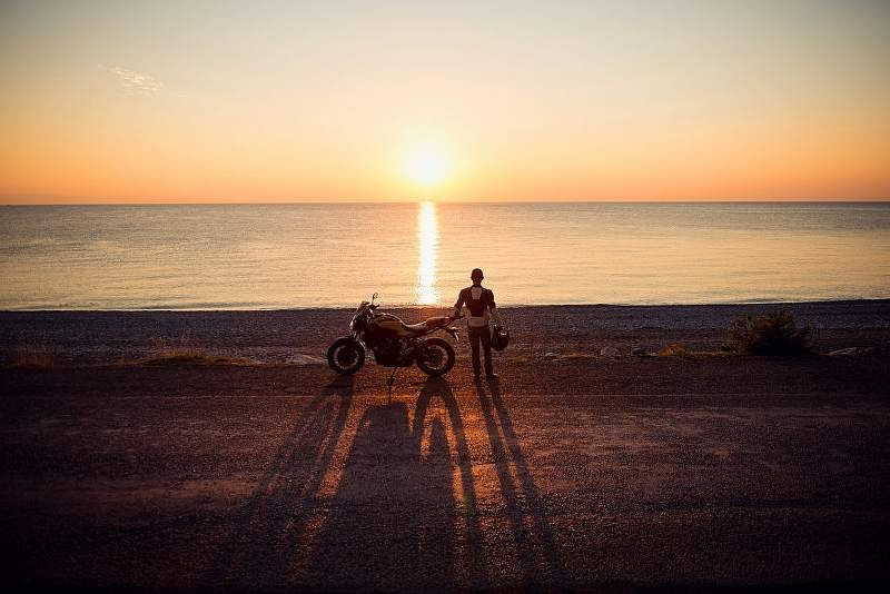Motorcycle rider on the beach at sunrise_800x534