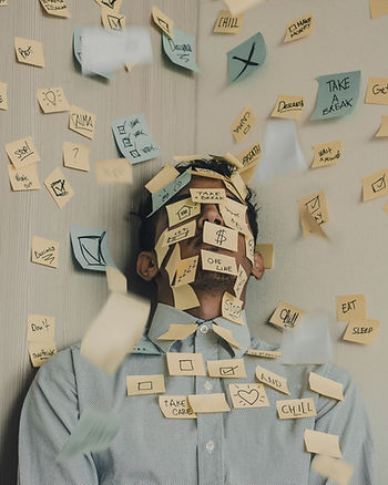 A man stands amidst a colorful array of sticky notes covering the walls, deep in thought or planning.