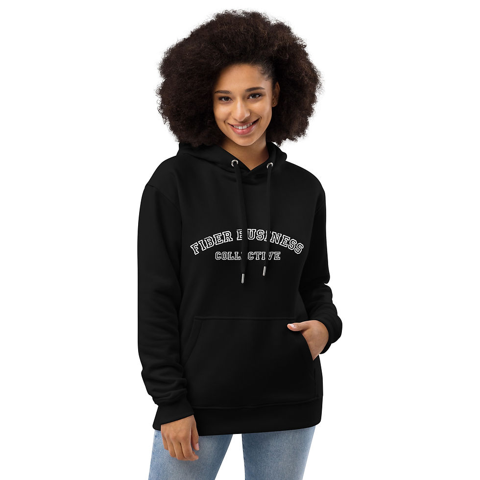 A woman with black curly hair wears a black hoodie with the words "Fiber Business Collective" across the chest in grey letters.