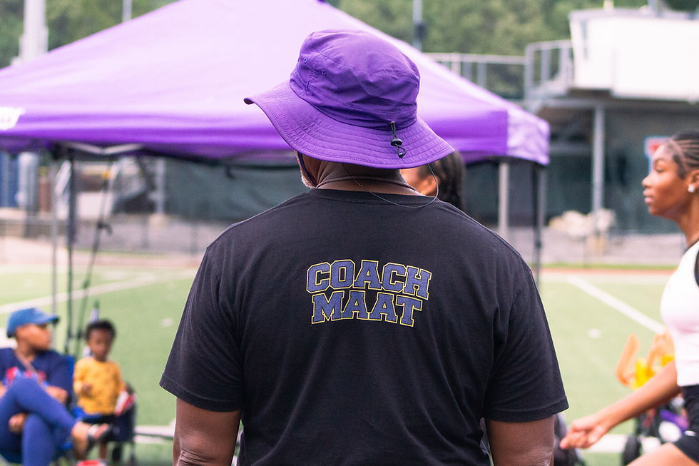 Coach Maat from behind with a bucket hat on guiding warm ups