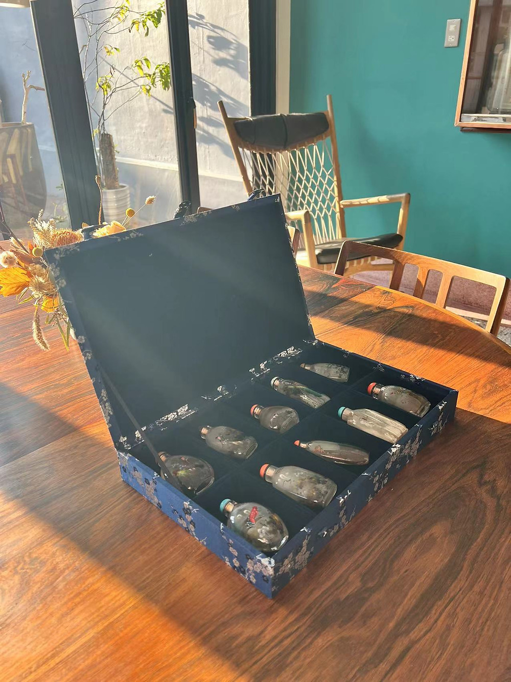 A customized brocade box with a decorative pattern contains collections of snuff bottles. D.D Art