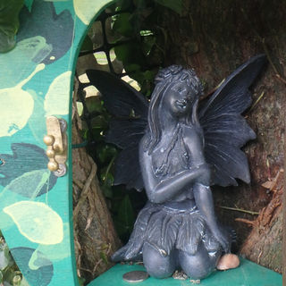 fairy sitting inside a garden fairy door
