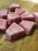 several berry ice block together on a wooden board.