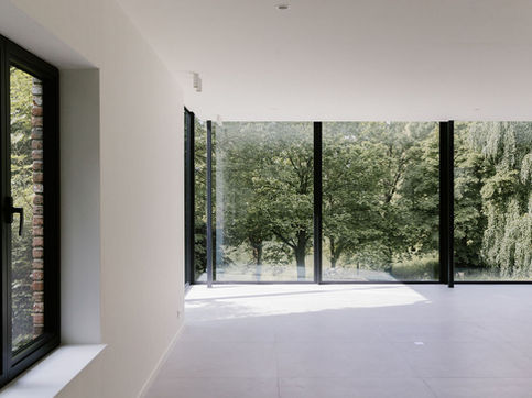 Rénovation d’une maison avec grandes baies vitrées ouvertes sur le jardin, réalisée par MiniM en Brabant wallon.