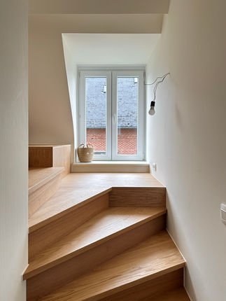 Palier et escalier en chêne aménagés sous les combles pour créer un accès lumineux au nouvel espace habitable.