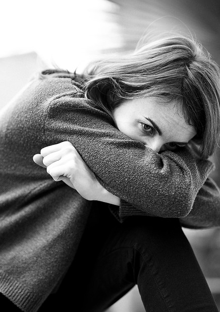 Woman curled up experiencing fear and panic — panic attack therapy in St. Petersburg, FL